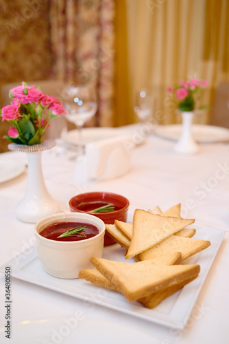Plate with toasted bread and sauce on table, copy space