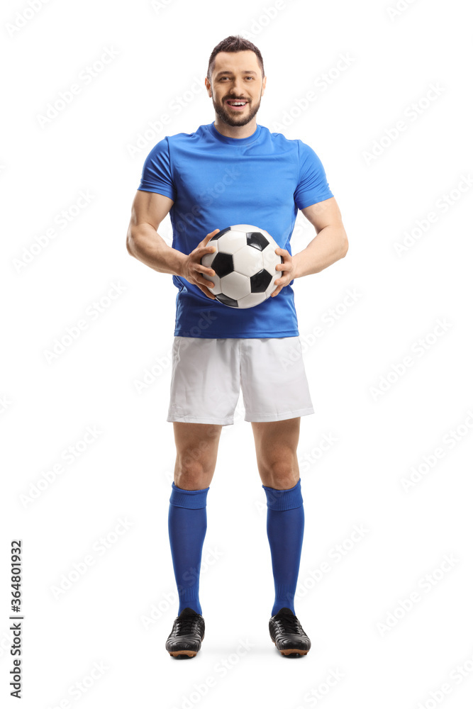 Soccer player holding a ball and looking at the camera