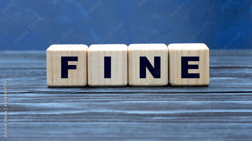 concept word FINE on wooden cubes on a gray background concept word FINE on wooden cubes on a gray background