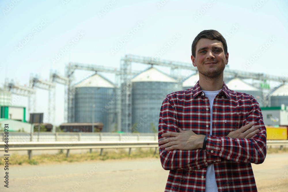 Young man against grain silos. Agriculture business Young man against grain silos. Agriculture business