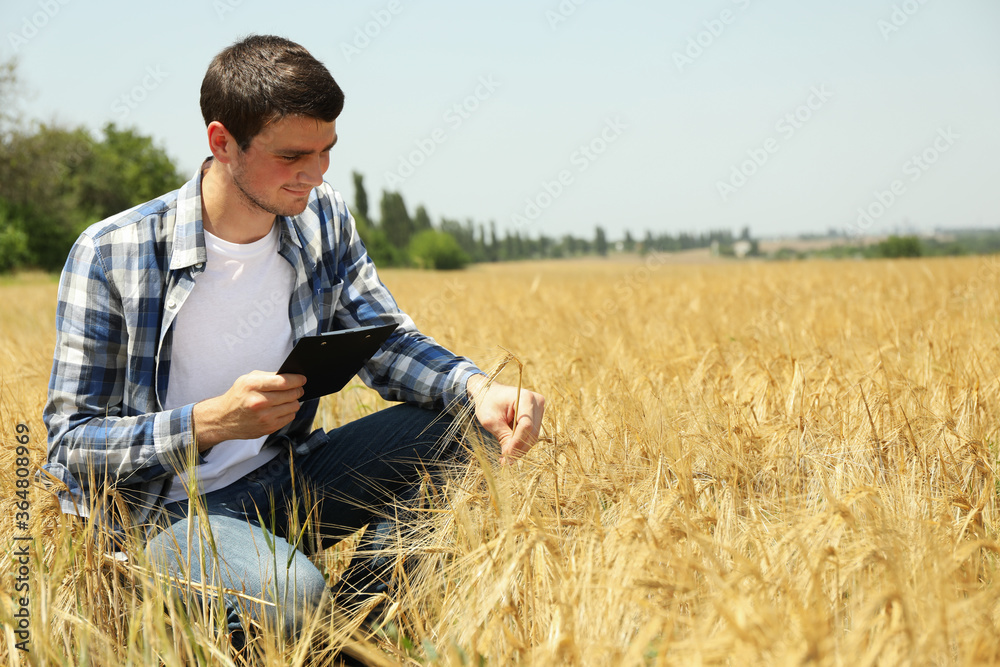 Young man with clipboard in barley field. Agriculture business Young man with clipboard in barley field. Agriculture business