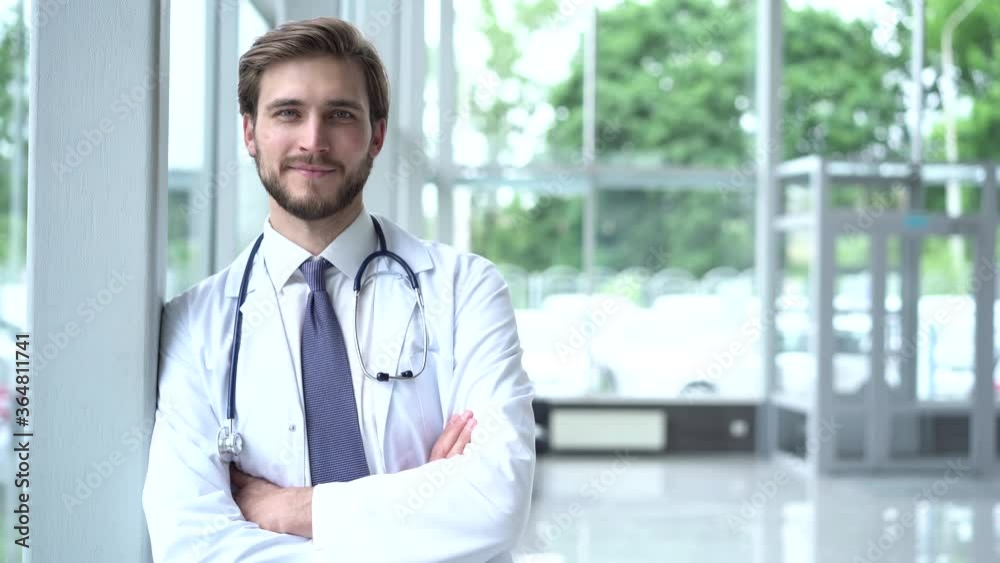 Portrait of smiling male doctor satisfied with his job in a corridor of a hospital. Concept of medicine, technology, health care and people, hospital Portrait of smiling male doctor satisfied with his job in a corridor of a hospital. Concept of medicine, technology, health care and people, hospital