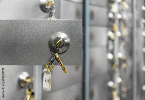 Open doors of deposit boxes with keys in the lock. Bank depository