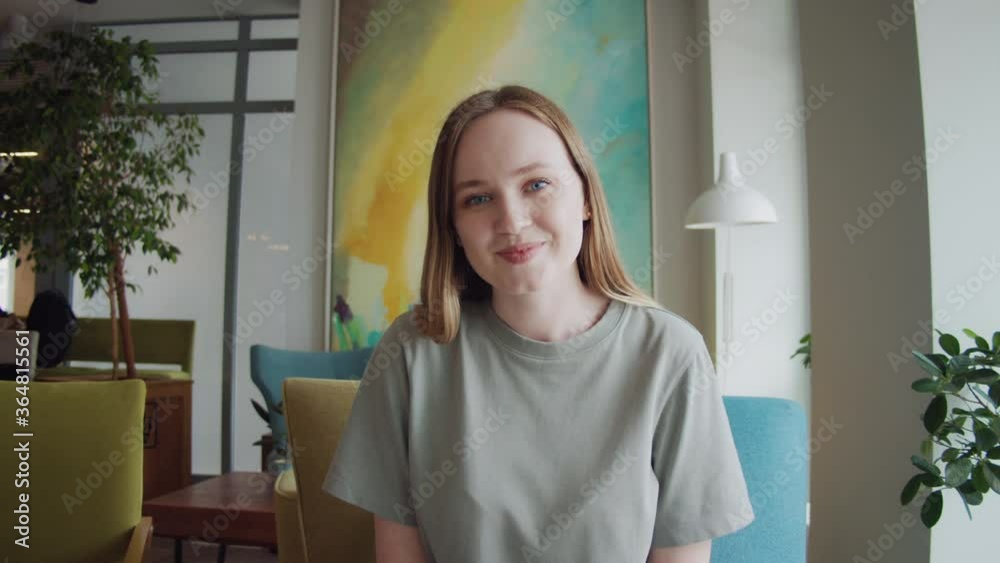 Attractive young woman video chatting, phone conference pov view. Girl student talking and waving at the camera while sitting at home, coronavirus home isolation.