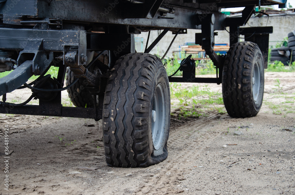 Old rusty tractor's flat back tire. industrial Old rusty tractor's flat back tire. industrial