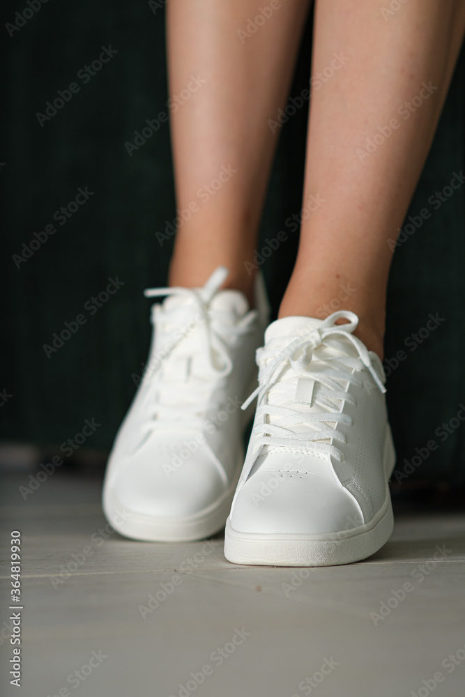 White women's sneakers dressed by a girl White women's sneakers dressed by a girl