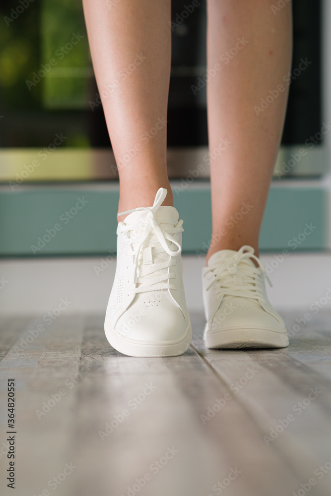 White women's sneakers dressed by a girl