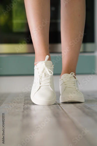 White women's sneakers dressed by a girl