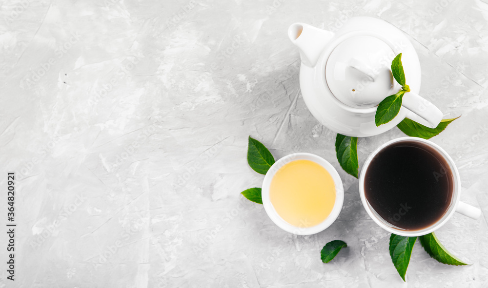 Herbal tea, cups and teapot with leaves on grey concrete background. Flat lay. Herbal tea, cups and teapot with leaves on grey concrete background. Flat lay.