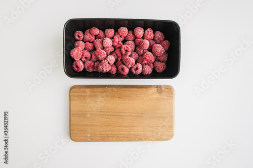 frozen raspberry in a lunch box on white background photo