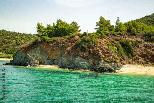 A beach in the Greek archipelago in summer, a great azure, a clear sky, forest and mountains photo