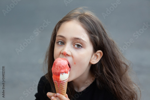 Portrait of a little girl who eating big ice cream photo