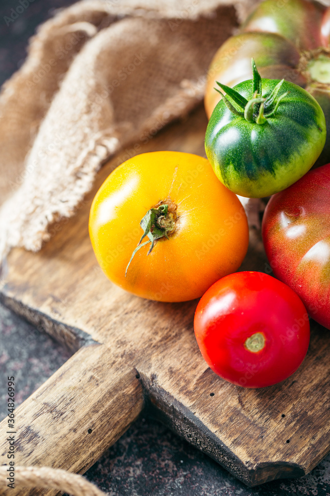 Fresh, ripe multi colored tomatoes on a dark background. Organic food. Fresh, ripe multi colored tomatoes on a dark background. Organic food.