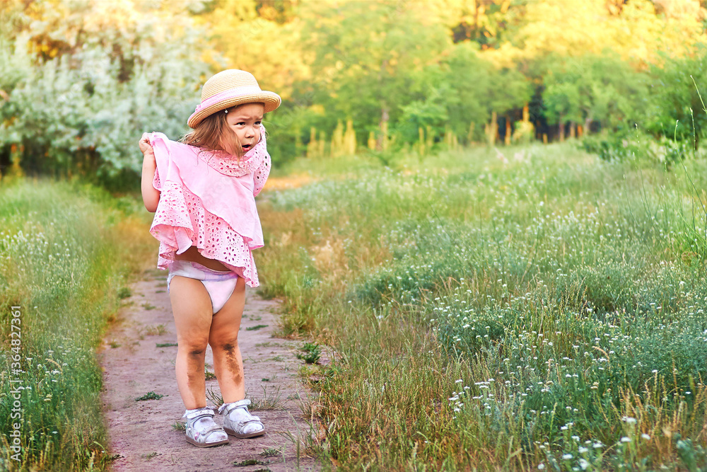 Crying little girl shows her dirty injured scratch knees. Girl fell while running or walking in park at summer time Crying little girl shows her dirty injured scratch knees. Girl fell while running or walking in park at summer time