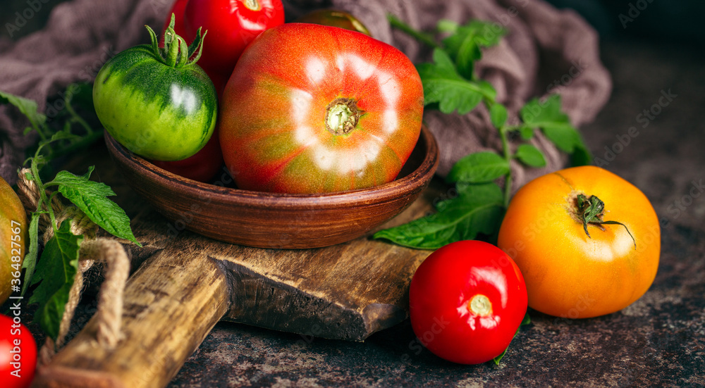 Fresh, ripe multi colored tomatoes on a dark background. Organic food. Fresh, ripe multi colored tomatoes on a dark background. Organic food.