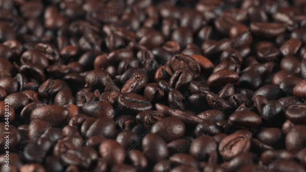 Roasted coffee beans background, close up. Fragrant coffee grains rotating Roasted coffee beans background, close up. Fragrant coffee grains rotating