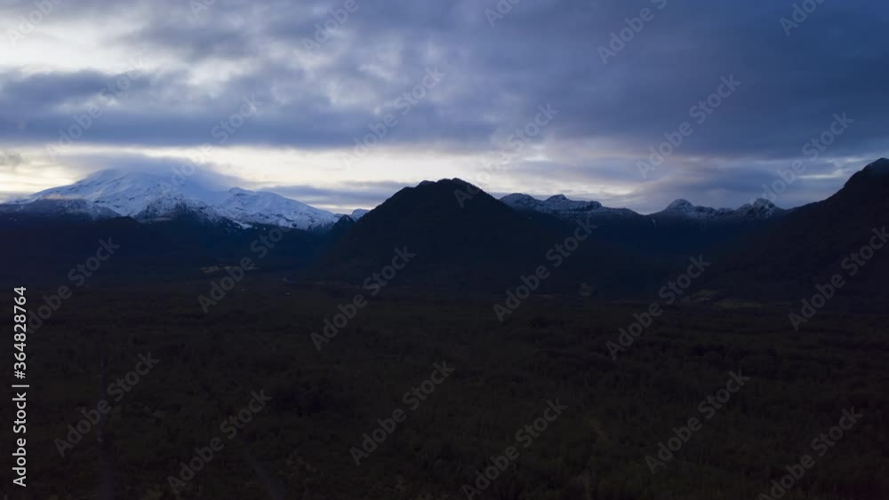 aerial hyperlapse over forests with snowy volcano in the background on a cloudy afternoon, Llanquihue national reserve aerial hyperlapse over forests with snowy volcano in the background on a cloudy afternoon, Llanquihue national reserve
