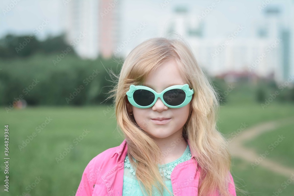 portrait of a beautiful little five year old girl in a city park
