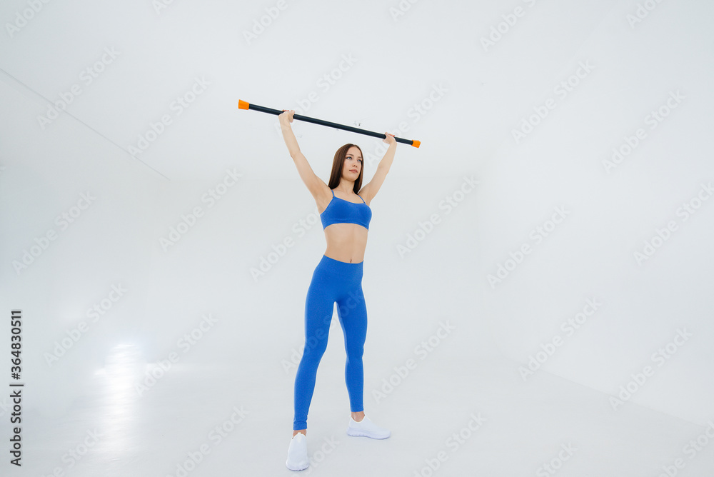 Sexy young girl performs sports exercises on a white background. Fitness, healthy lifestyle Sexy young girl performs sports exercises on a white background. Fitness, healthy lifestyle