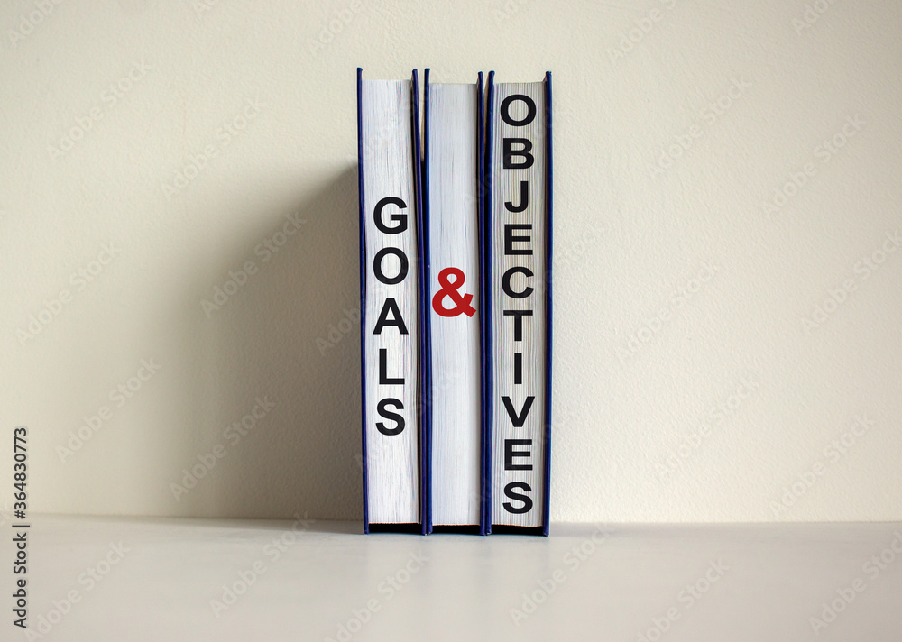 Books with text 'goals and objectives' on beautiful white background. Business concept. Copy space.