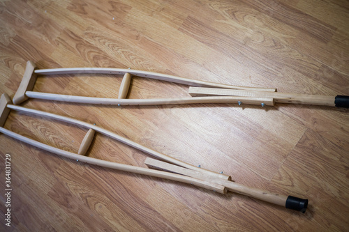 Wooden crutches on a wooden floor, for the movement of people with disabilities, people with fractures and sprains, or bone defects.