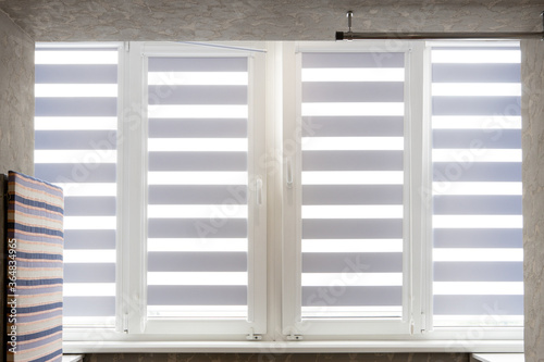 Fotografia Windows with open modern horizontal blinds indoors, closeup