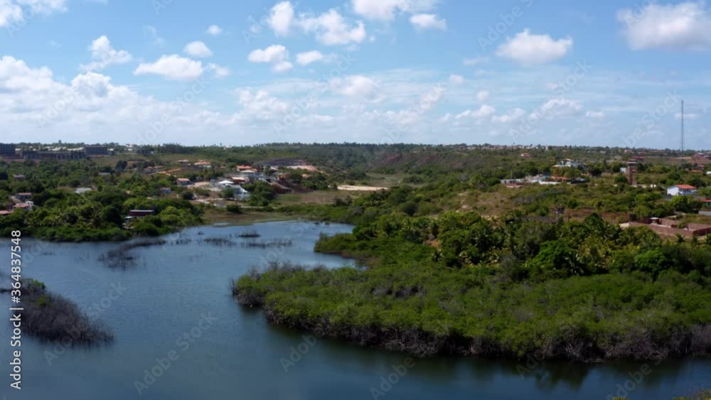 Beautiful rising aerial drone shot of a large amazonian river bending with a bridge across with cars passing entering the beach town of Tabatinga near Joao Pessoa in Northern Brazil. Beautiful rising aerial drone shot of a large amazonian river bending with a bridge across with cars passing entering the beach town of Tabatinga near Joao Pessoa in Northern Brazil.