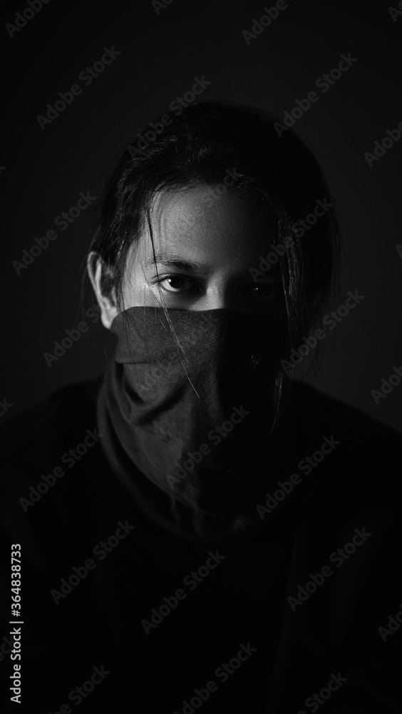 An Asian man with long hair wearing a gag. A ninja or long-haired robber in a black dress An Asian man with long hair wearing a gag. A ninja or long-haired robber in a black dress
