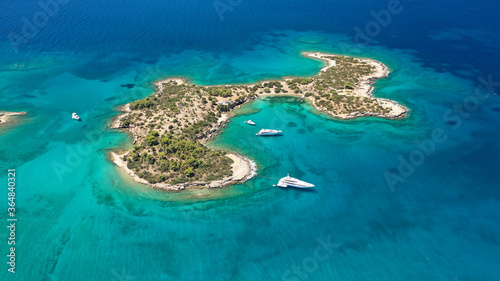 Aerial drone photo of Hinitsa bay a popular anchorage crystal clear turquoise sea bay for yachts and sailboats next to Porto Heli, Saronic gulf, Greece