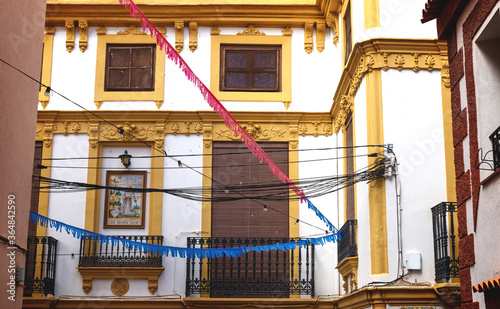 Historic house facade with yellow stucco and tile painting of Siant Francesco Assisi in Polop de Marina, Spain photo