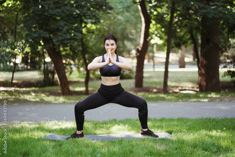 Fit woman doing morning yoga exercises in the park. Tranquility and concentration. Healthy lifestyle Fit woman doing morning yoga exercises in the park. Tranquility and concentration. Healthy lifestyle