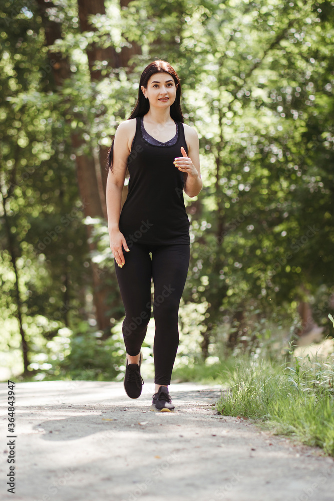 Sport, fitness, healthy lifestyle, cardio training. Active woman with athletic body running in the park. Female jogger working out outdoor