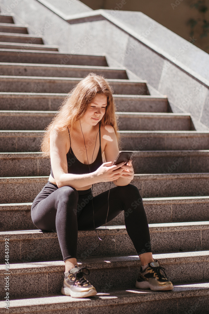 Fitness app, sport gadget, outdoor workout and technology. Fit woman with smart phone in the street Fitness app, sport gadget, outdoor workout and technology. Fit woman with smart phone in the street