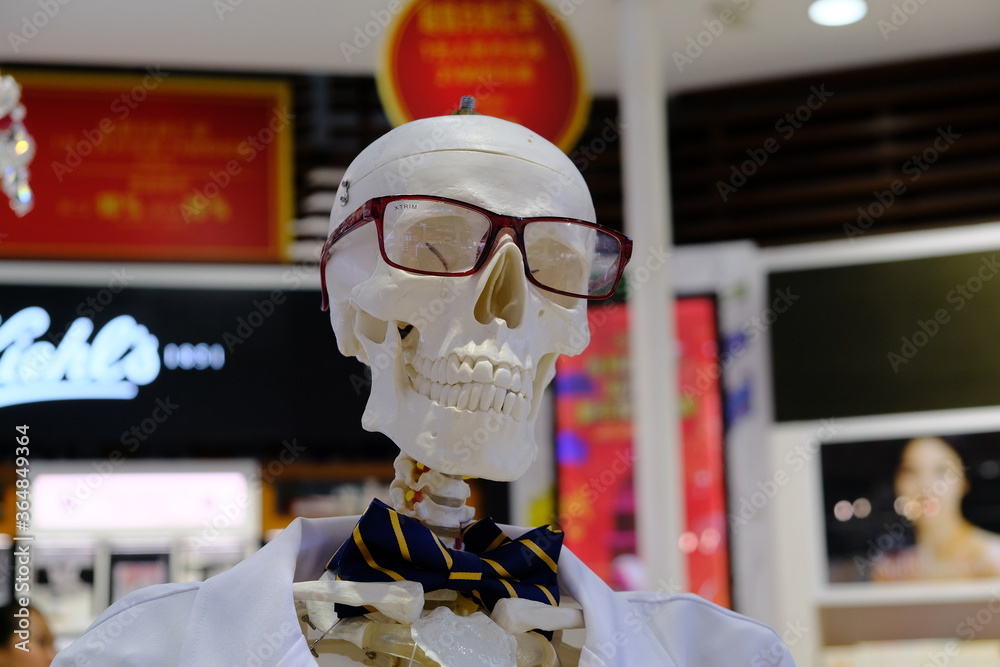 Fototapeta premium Bali, Indonesia - January 13 2020: A skeleton in glasses, a robe and a bow tie in the Duty free shop at the airport.