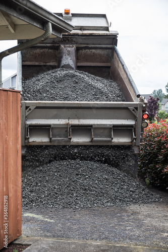 Dump Truck Unloading Crushed Rock at Home Driveway for Gravel Delivery