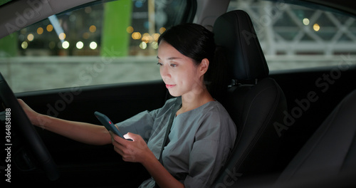 Woman use of mobile phone in car at night © leungchopan