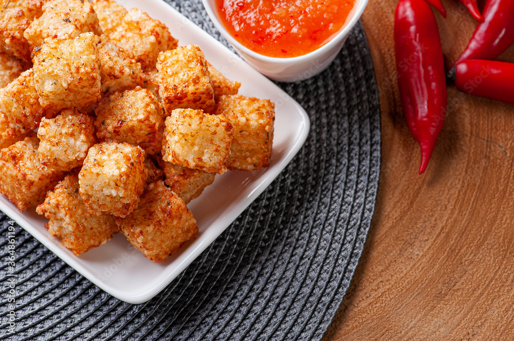 .Squares of tapioca and cheese served with pepper jelly. Wooden table. Space for text - Dice of tapioca. Top view. Copy space .Squares of tapioca and cheese served with pepper jelly. Wooden table. Space for text - Dice of tapioca. Top view. Copy space