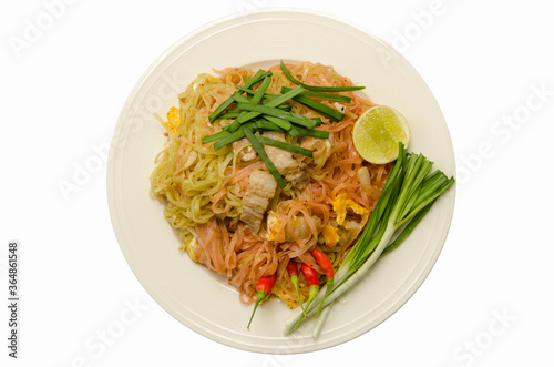 Fried Thai noodles dish with streaky pork dish with herbs on white background