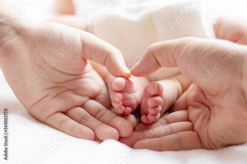 Baby and mother and father holding footers, cropped, close-up