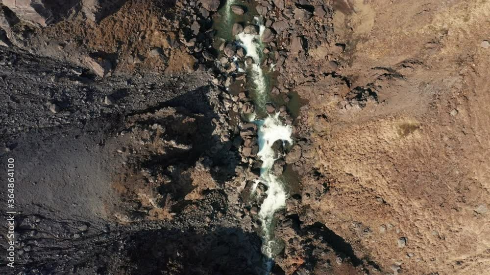 Bessastadaa River Flowing On The Rocks In East Iceland On A Sunny Day. -top view - aerial drone Bessastadaa River Flowing On The Rocks In East Iceland On A Sunny Day. -top view - aerial drone
