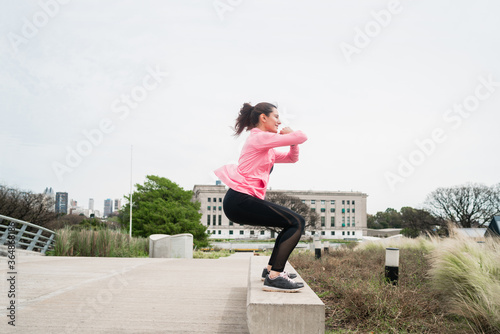 Athletic woman doing exercise at the park.