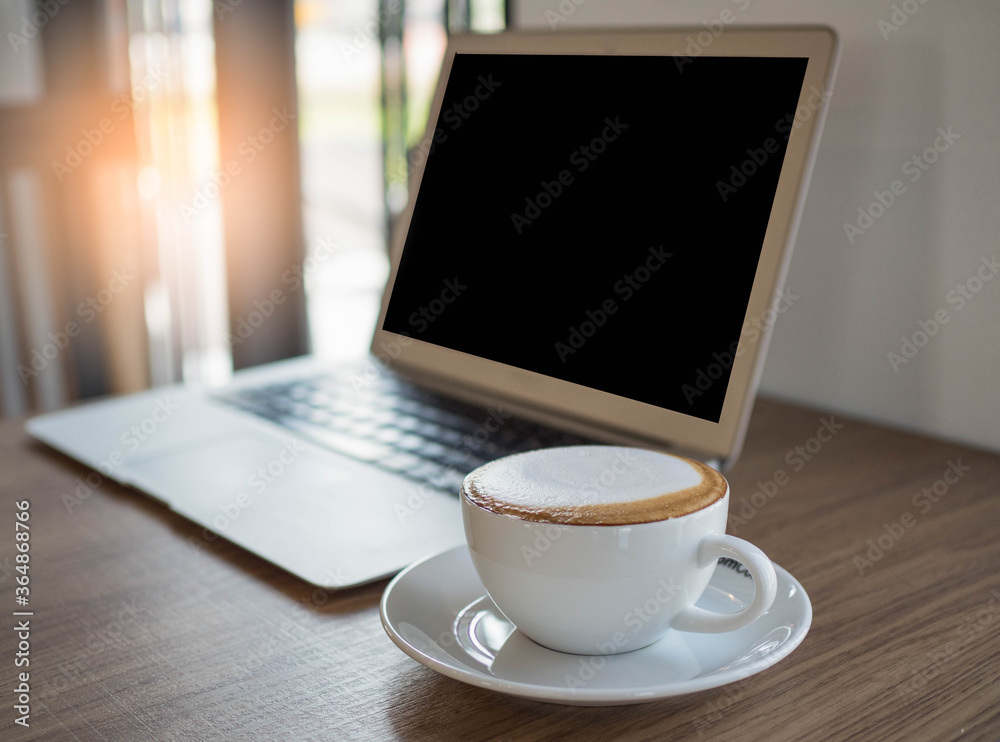 cup of coffee on the table with laptop on table in cafe. cup of coffee on the table with laptop on table in cafe.