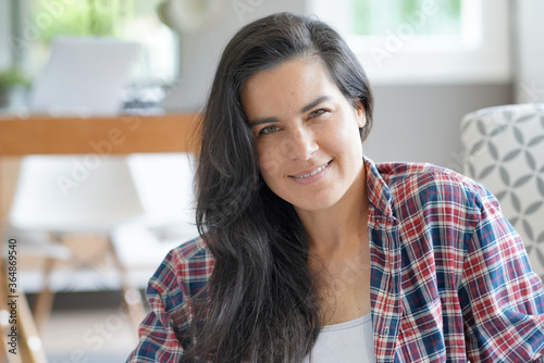 Portrait of beautiful and smiling dark-haired woman relaxing at home