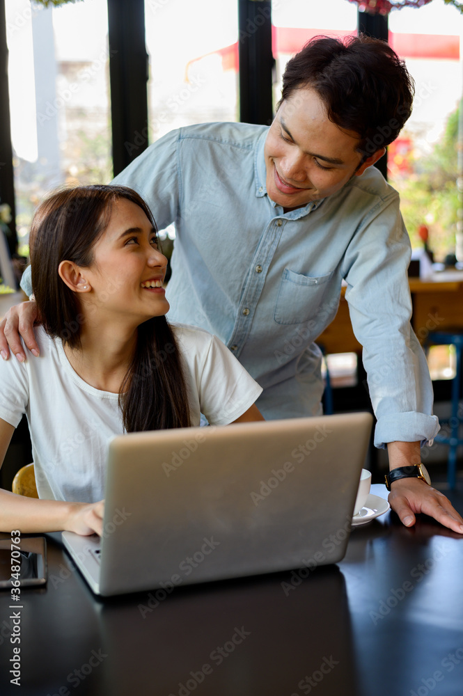 Asian young girl and guy working with laptop in coffee shop cafe Asian young girl and guy working with laptop in coffee shop cafe