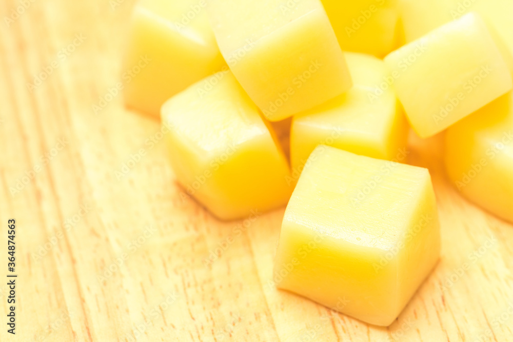 Close Up of Mozzarella Cheese Cubes on Wooden Plate Isolated on White Background Close Up of Mozzarella Cheese Cubes on Wooden Plate Isolated on White Background