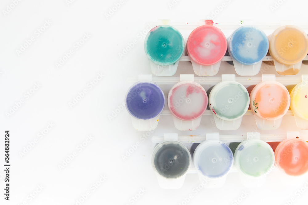 jars with gouache paints on a white background