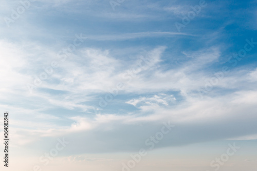 Fototapeta Naklejka Na Ścianę i Meble -  White clouds stretched across the blue sky on a warm sunny day