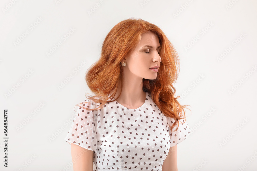 Beautiful young redhead woman on light background Beautiful young redhead woman on light background