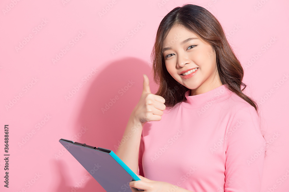 Young Asian woman doing business style poses in front of pink studio background Young Asian woman doing business style poses in front of pink studio background