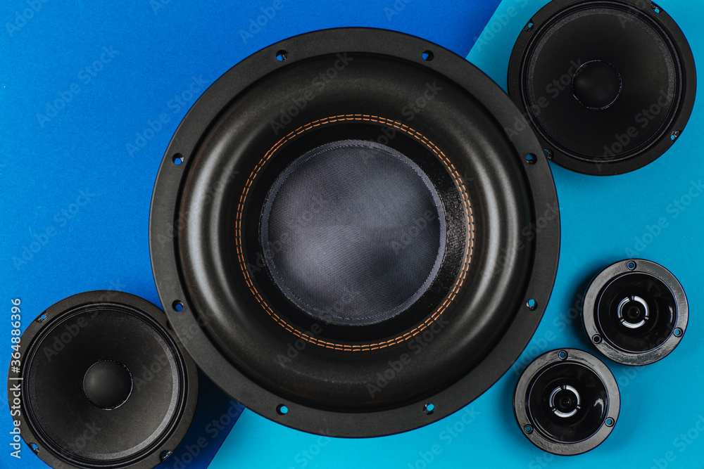 Car audio, car speakers, black subwoofer on a blue-light blue background. Close up Car audio, car speakers, black subwoofer on a blue-light blue background. Close up